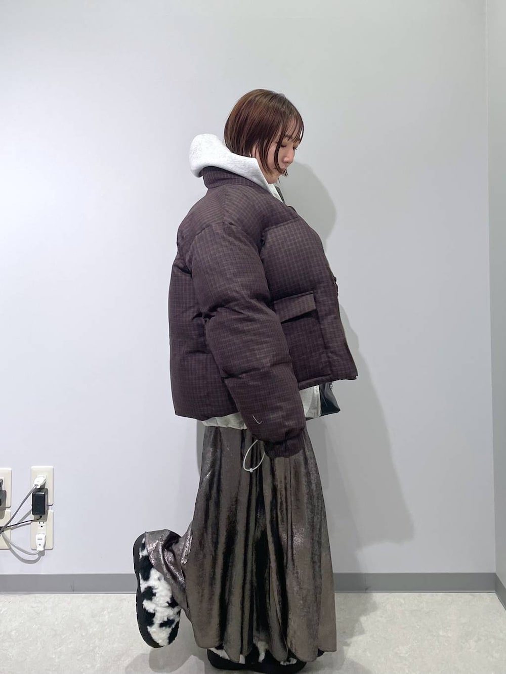 ホワイト系のスリッポン、ブラック系のボストンバッグ、ブラウン系のブルゾンを着用したレディースの冬コーディネートの2枚目の写真