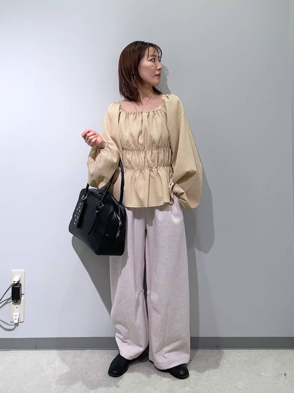 ピンク系のスウェットパンツ、ブラック系のボストンバッグ、ベージュ系のTシャツ/カットソーを着用したレディースの春コーディネートの3枚目の写真