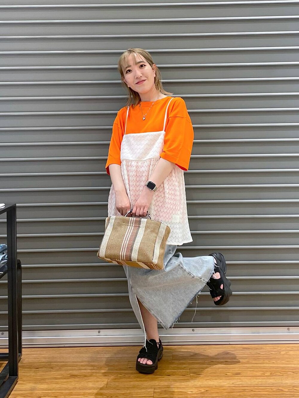 ホワイト系のTシャツ/カットソー、ブルー系のスカート、ブラウン系のショルダーバッグを着用したレディースの春コーディネートの2枚目の写真