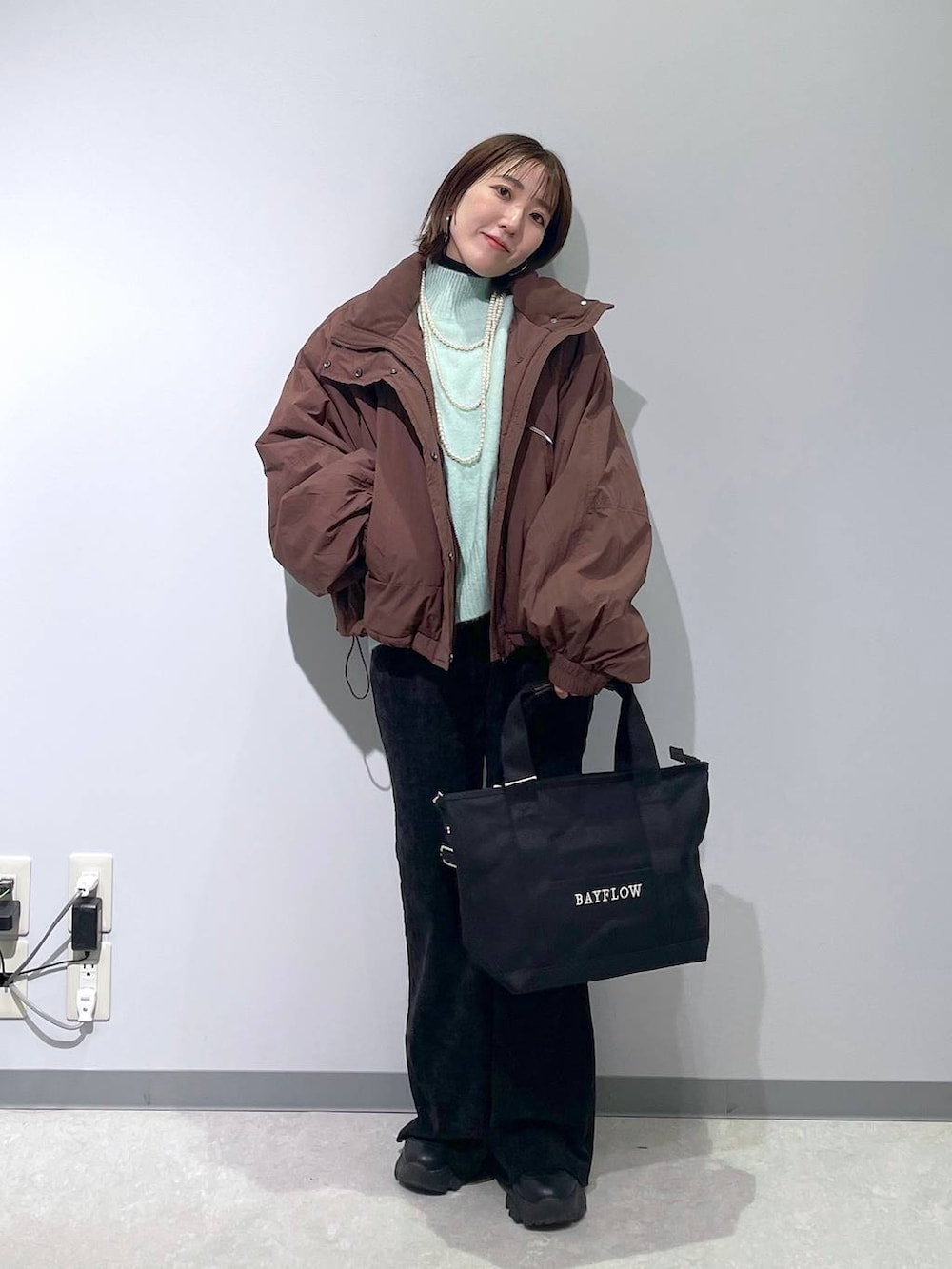 ブラウン系のその他アウター、グリーン系のニット/セーター、ブラック系のその他パンツを着用したレディースの冬コーディネートの2枚目の写真