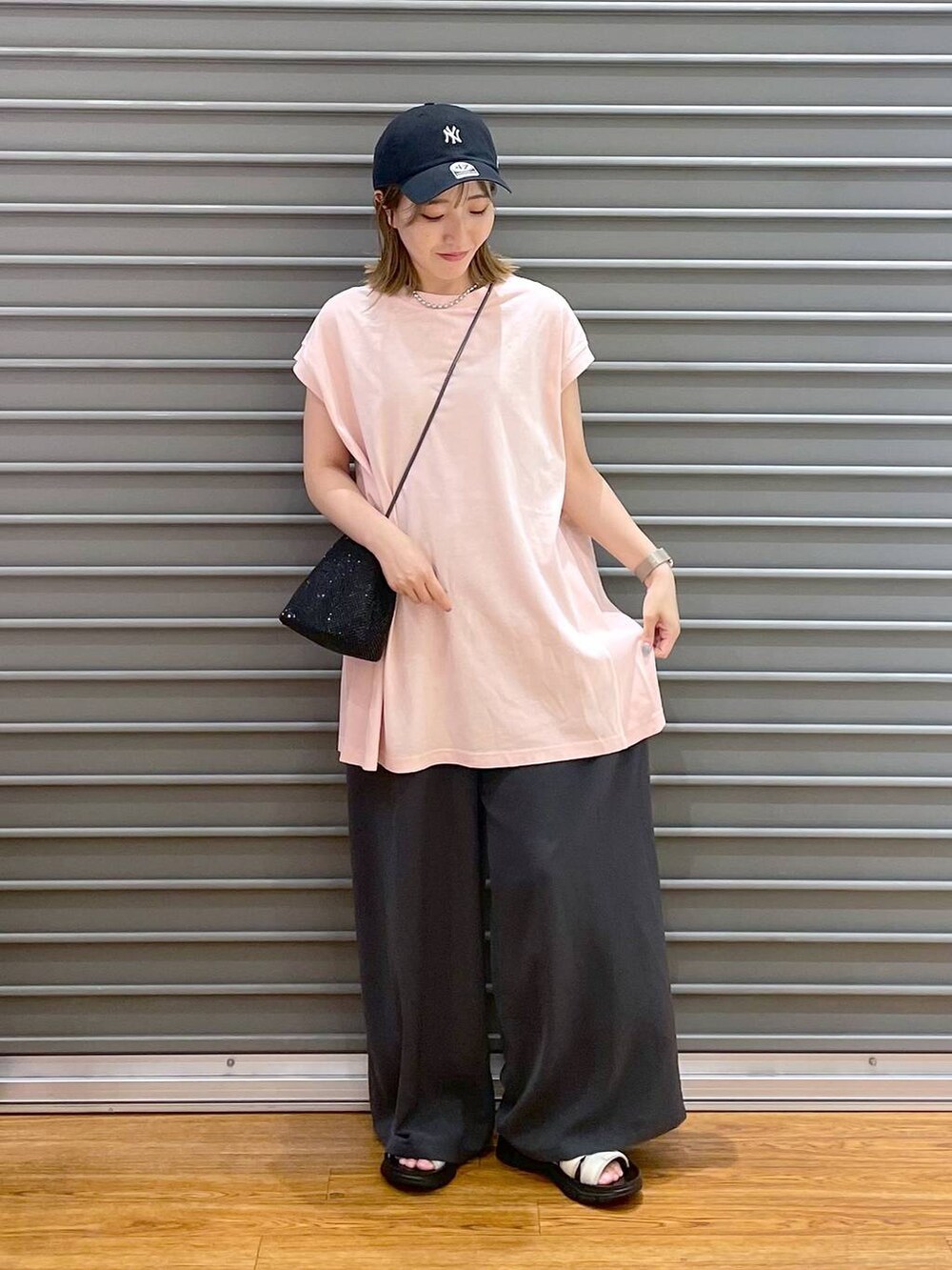 ブラック系のショルダーバッグ、ピンク系のTシャツ/カットソー、グレー系のその他パンツを着用したレディースの夏コーディネートの3枚目の写真