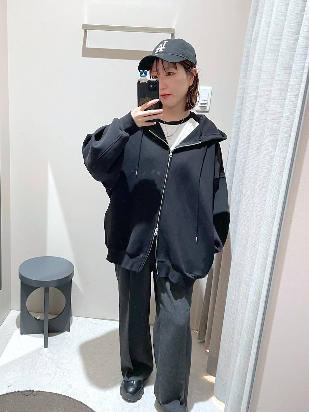 ブラック系のパーカー、ブラック系のキャップを着用したレディースの冬コーディネートの2枚目の写真