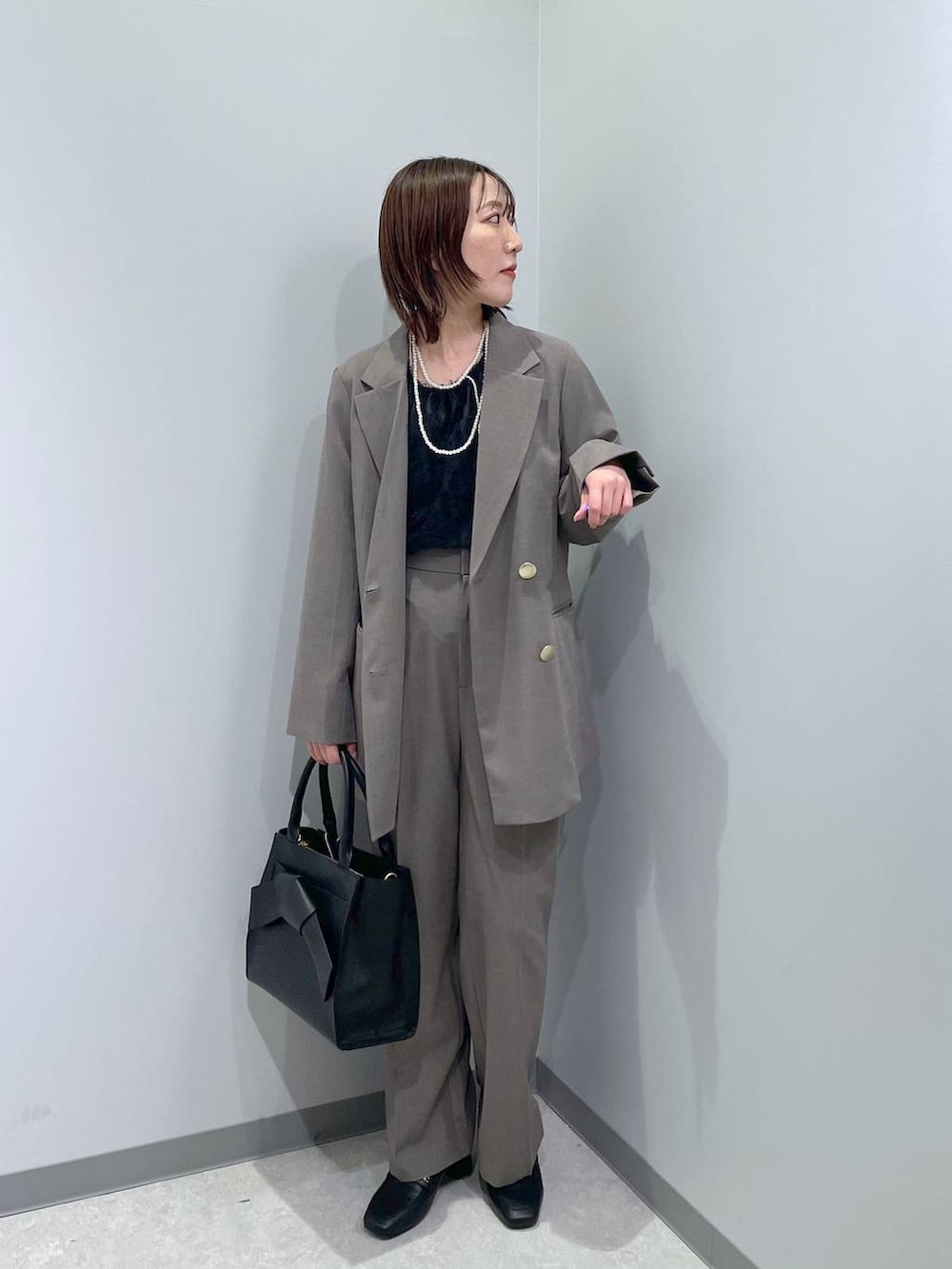 ブラック系のローファー、ブラック系のシャツ/ブラウス、ブラウン系のスラックスを着用したレディースの冬コーディネートの2枚目の写真