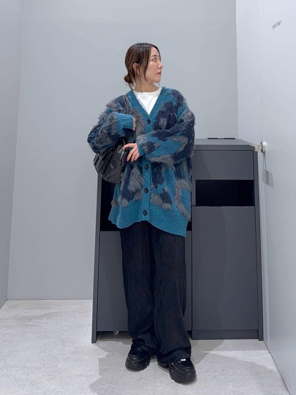 ブラック系のボストンバッグ、ブラック系のその他パンツ、ブルー系のカーディガン/ボレロを着用したレディースの秋コーディネートの2枚目の写真