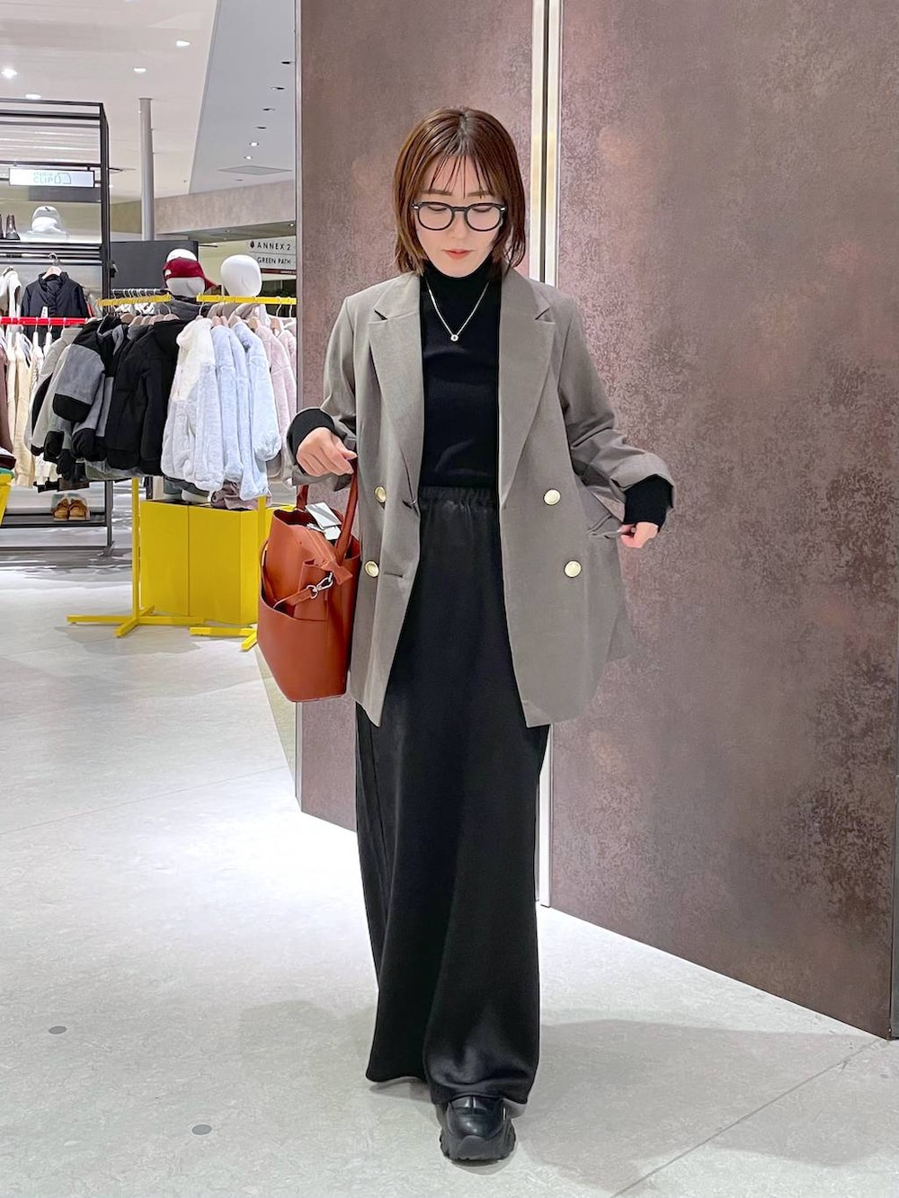 ブラック系のスカート、ブラック系のニット/セーター、レッド系のショルダーバッグを着用したレディースの冬コーディネートの3枚目の写真