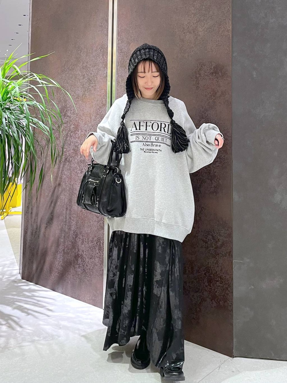 ブラック系のボストンバッグ、グレー系のスウェット、ブラック系のスカートを着用したレディースの秋コーディネートの2枚目の写真