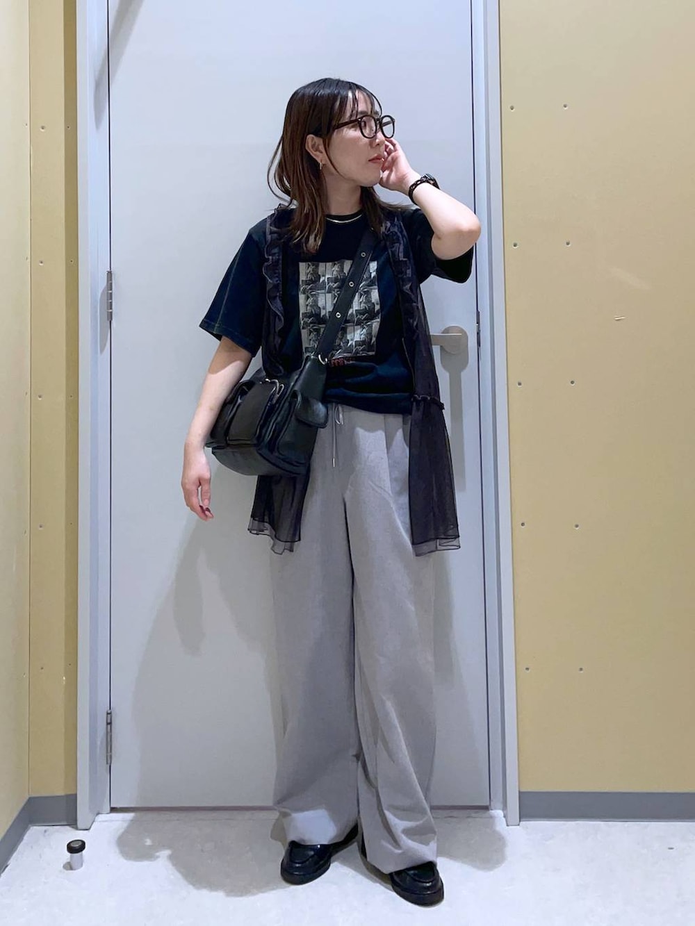 ブラック系のショルダーバッグ、グレー系のその他パンツ、ブラック系のベストを着用したレディースの春コーディネートの2枚目の写真