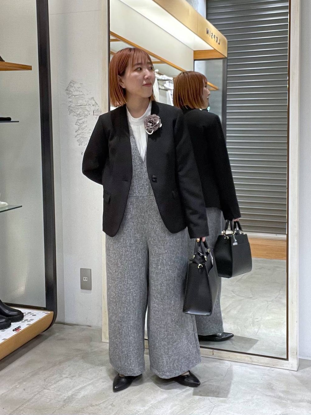 ブラック系のノーカラージャケット、ホワイト系のサロペット/オーバーオール、ホワイト系のシャツ/ブラウスを着用したレディースの冬コーディネートの4枚目の写真