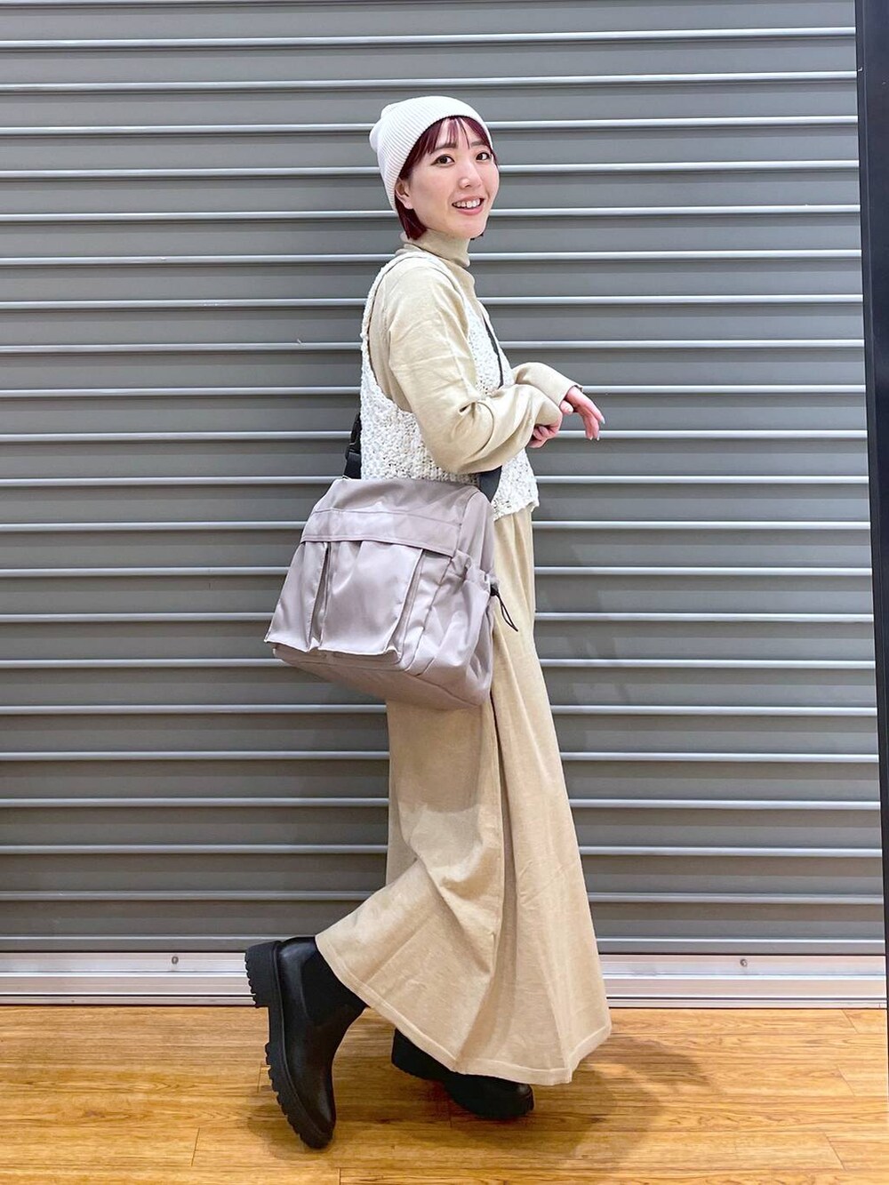 ホワイト系のワンピース、ブラック系のブーツ、グレー系のショルダーバッグを着用したレディースの冬コーディネートの2枚目の写真