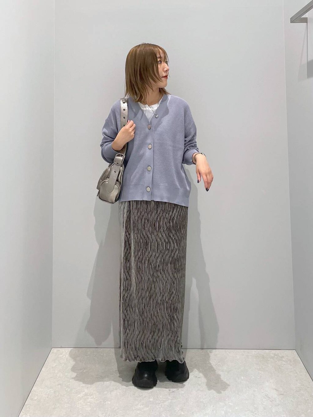 ブルー系のカーディガン/ボレロ、シルバー系のショルダーバッグ、ホワイト系のTシャツ/カットソーを着用したレディースの秋コーディネートの3枚目の写真