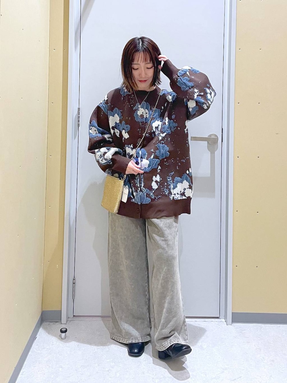 ゴールド系のショルダーバッグ、ブラウン系のカーディガン/ボレロ、グレー系のスウェットパンツを着用したレディースの秋コーディネートの4枚目の写真