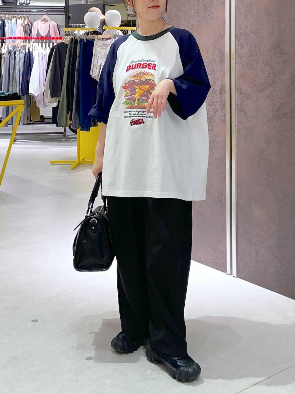 ブラック系のボストンバッグ、ブルー系のTシャツ/カットソーを着用したレディースの春コーディネートの2枚目の写真