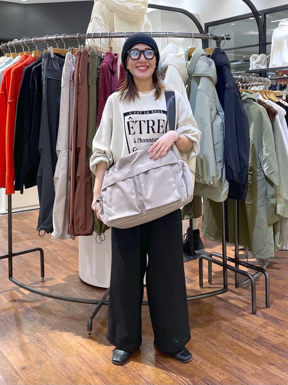 ホワイト系のニット/セーター、ブラック系のその他パンツ、グレー系のショルダーバッグを着用したレディースの冬コーディネートの4枚目の写真