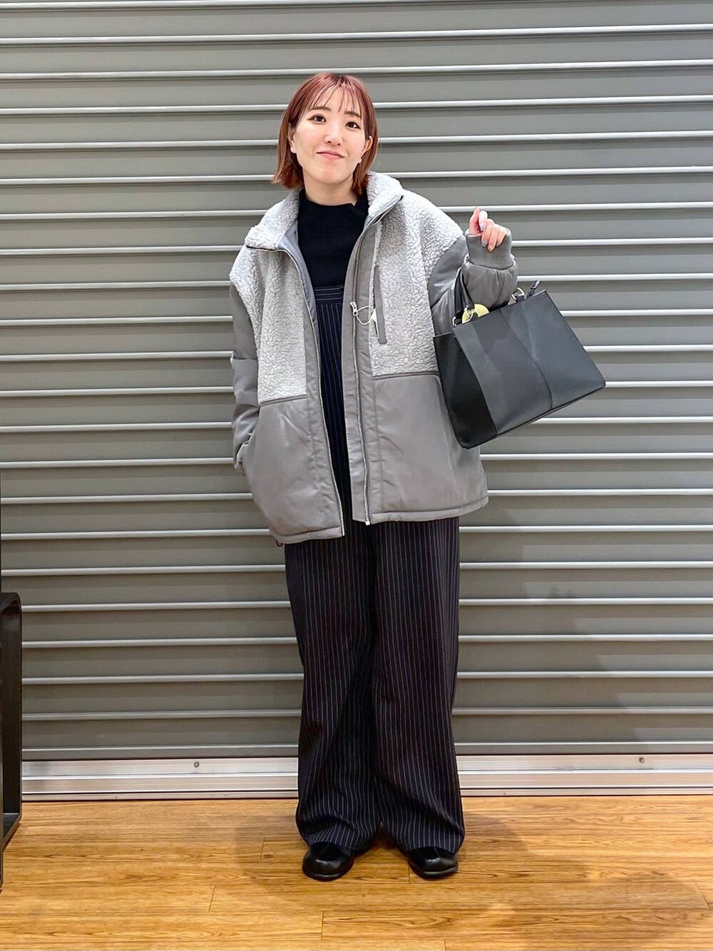 ブラック系のニット/セーター、グレー系のその他アウター、ブラック系のショルダーバッグを着用したレディースの冬コーディネートの2枚目の写真