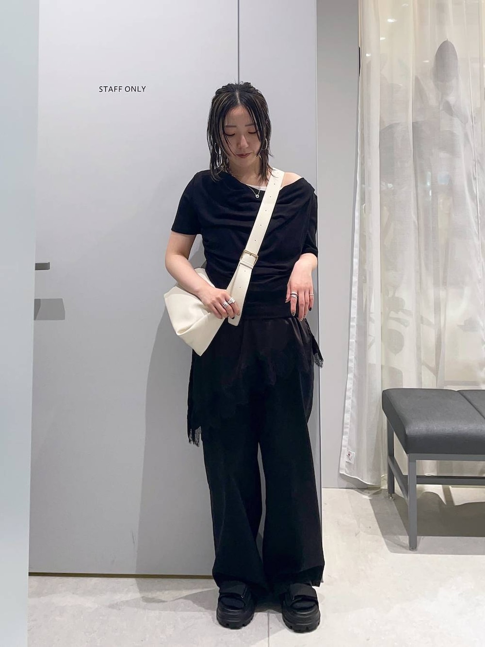 ブラック系のTシャツ/カットソー、ブラック系のサンダル、ホワイト系のショルダーバッグを着用したレディースの春コーディネートの2枚目の写真
