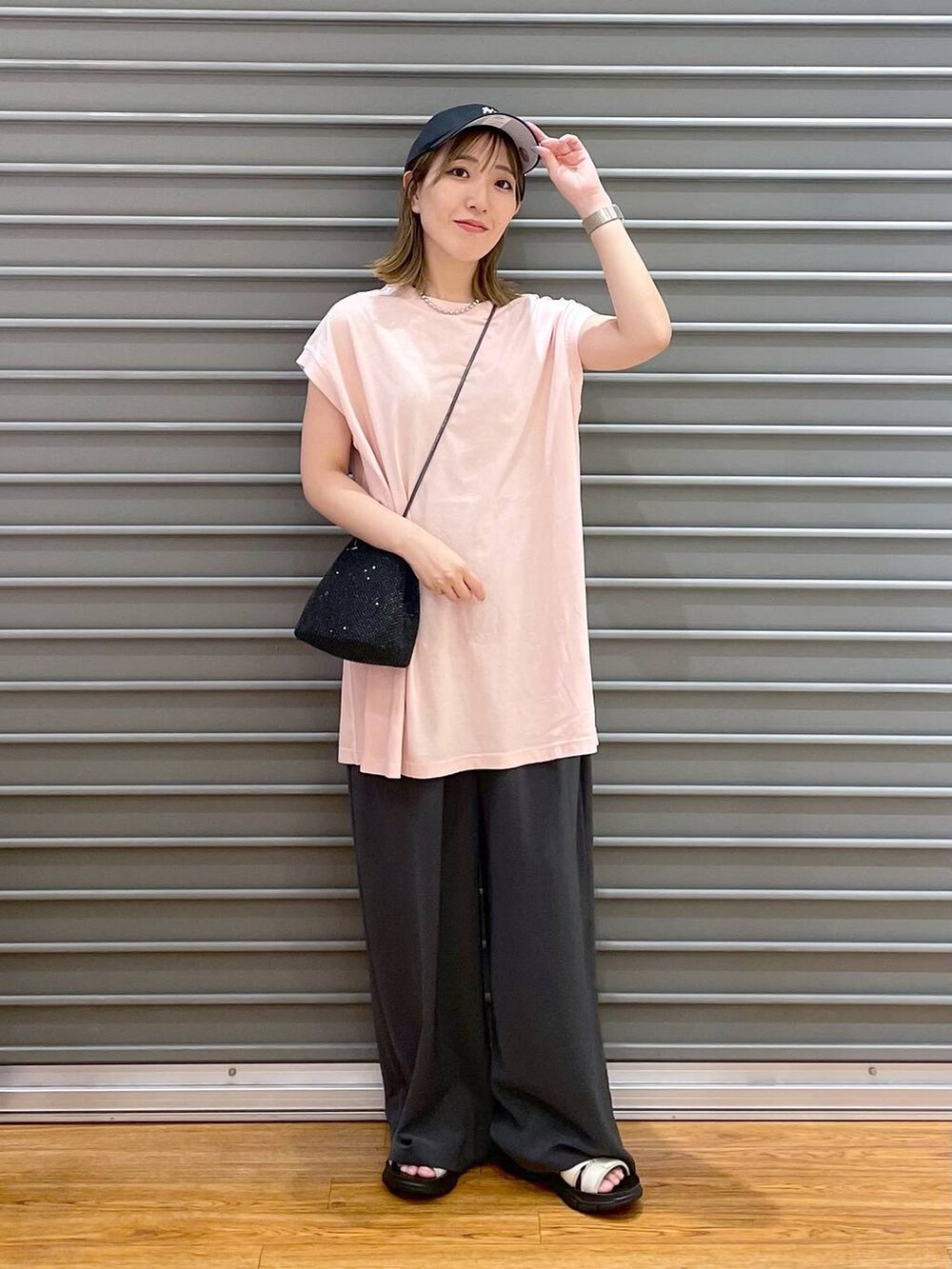 ブラック系のショルダーバッグ、ピンク系のTシャツ/カットソー、グレー系のその他パンツを着用したレディースの夏コーディネートの2枚目の写真