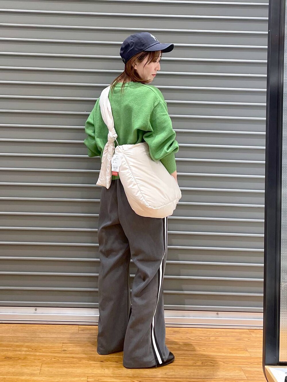 ブラック系のブーツ、ホワイト系のショルダーバッグ、グレー系のその他パンツを着用したレディースの冬コーディネートの2枚目の写真