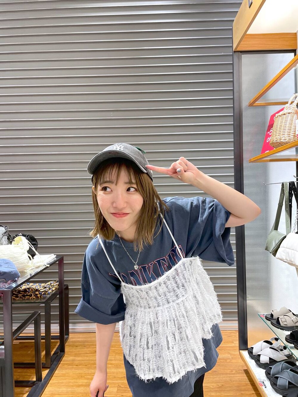 レッド系のショルダーバッグ、ブルー系のTシャツ/カットソー、ブラック系のスカートを着用したレディースの夏コーディネートの3枚目の写真
