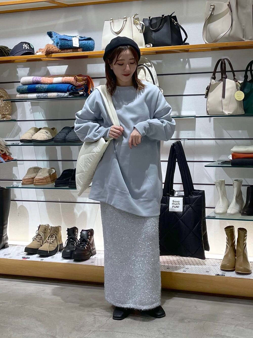 ホワイト系のトートバッグ、シルバー系のスカート、ブルー系のスウェットを着用したレディースの冬コーディネートの4枚目の写真