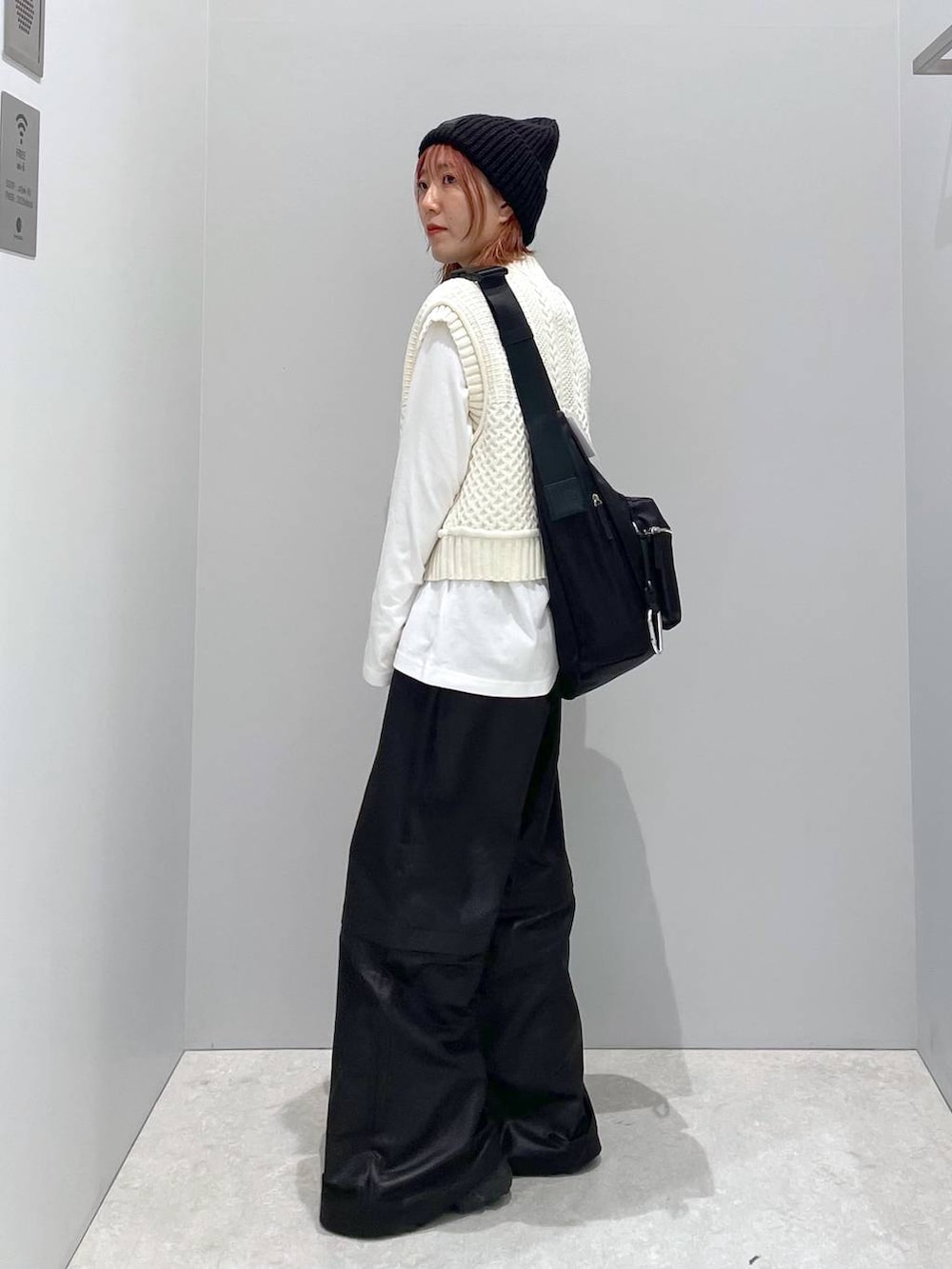 ホワイト系のベスト、ブラック系のショルダーバッグ、ホワイト系のTシャツ/カットソーを着用したレディースの秋コーディネートの2枚目の写真