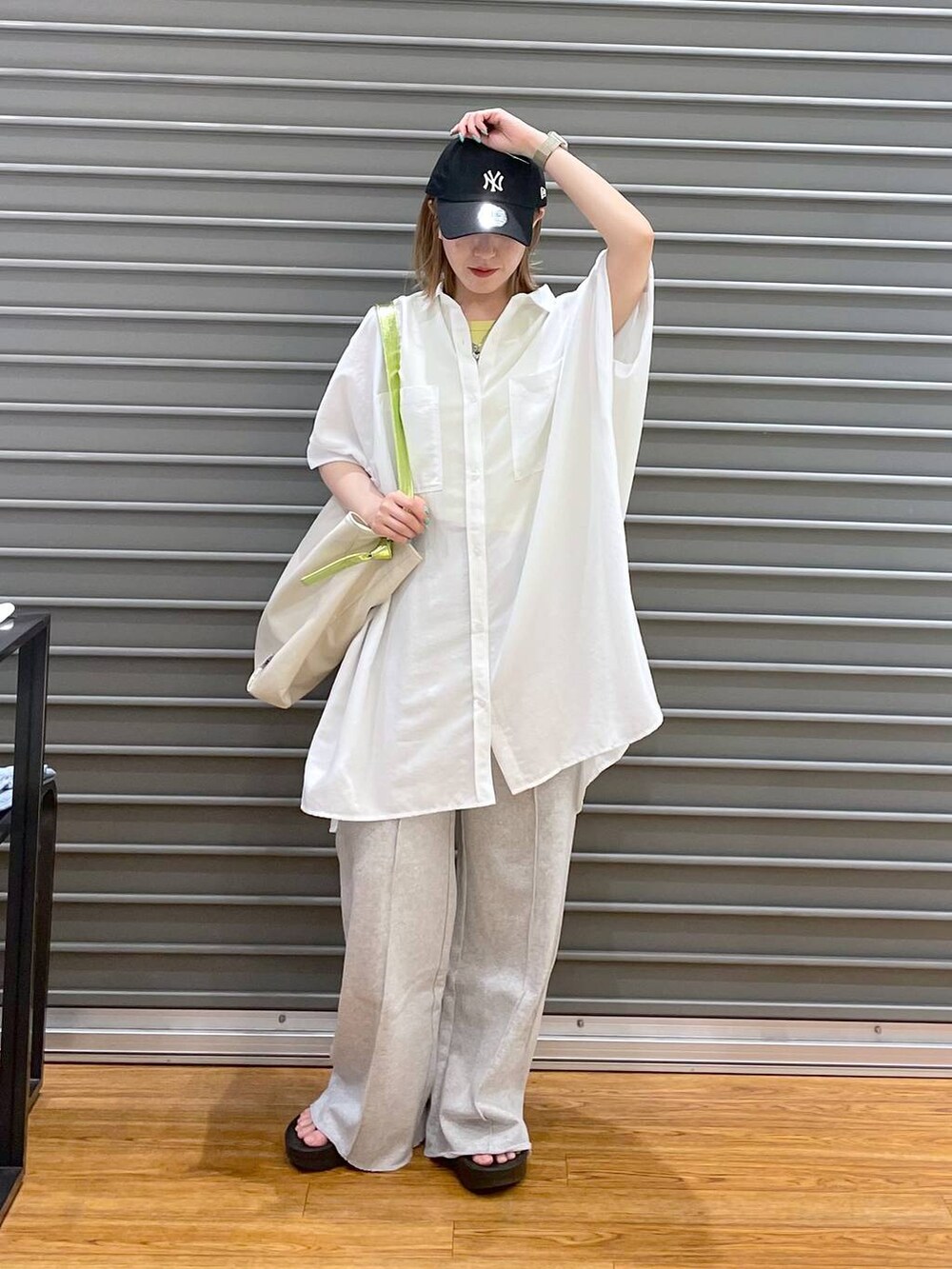 グレー系のスウェットパンツ、ブラック系のサンダル、ホワイト系のチュニックを着用したレディースの春コーディネートの3枚目の写真