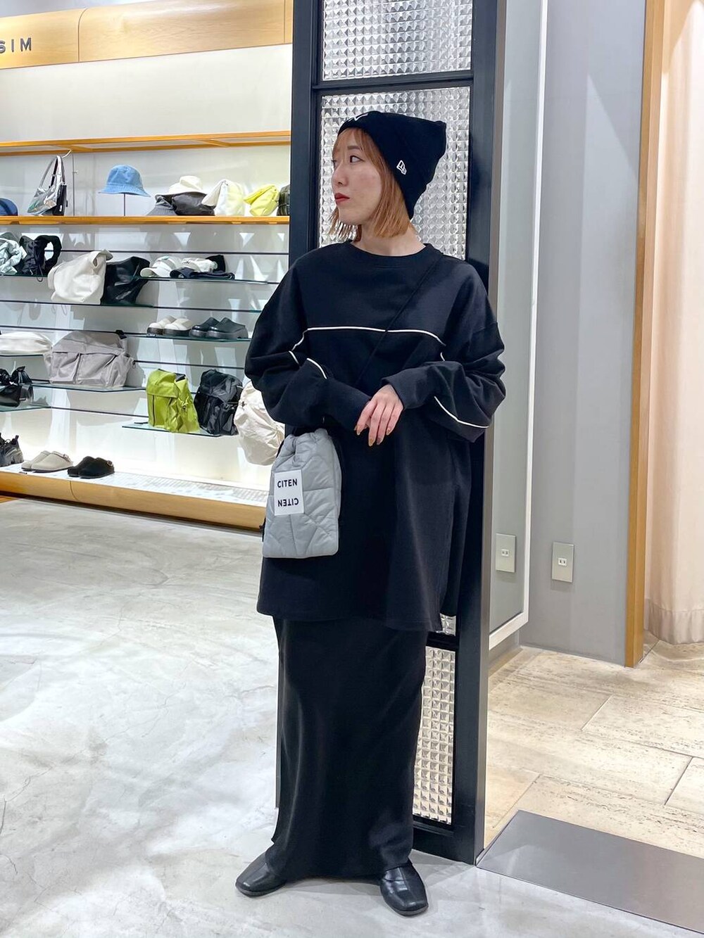 ブラック系のスカート、ブラック系のチュニック、ブラック系のニットキャップ/ビーニーを着用したレディースの冬コーディネートの2枚目の写真