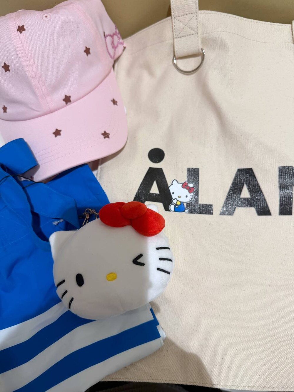 ホワイト系のトートバッグ、ピンク系のキャップを着用したレディースの夏コーディネートの2枚目の写真