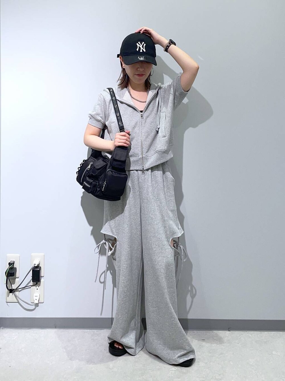 ブラック系のサンダル、グレー系のスウェットパンツ、ブラック系のショルダーバッグを着用したレディースの夏コーディネートの2枚目の写真