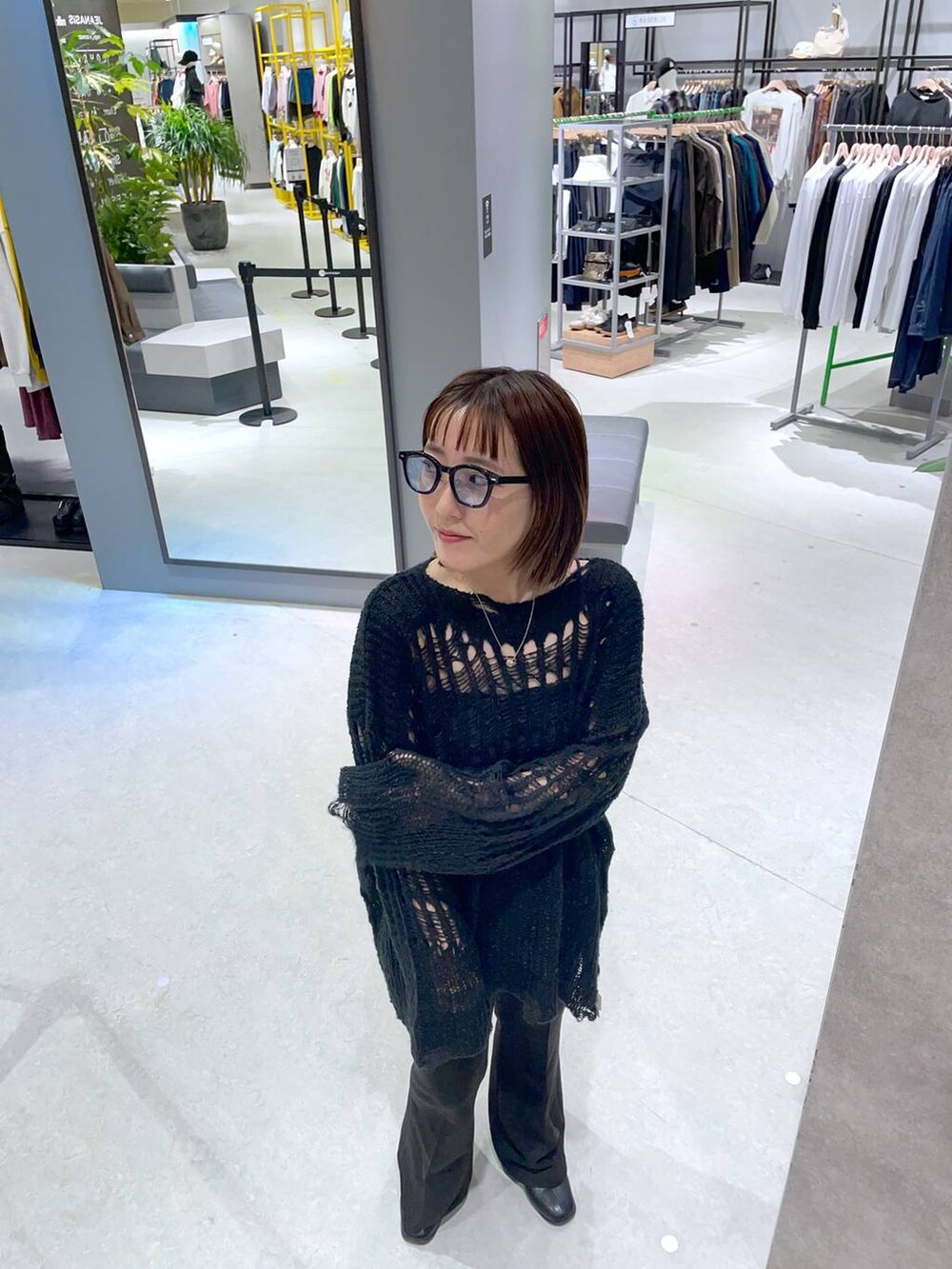ブラック系のその他パンツ、ブラック系のニット/セーター、ブルー系のその他小物を着用したレディースの秋コーディネートの3枚目の写真