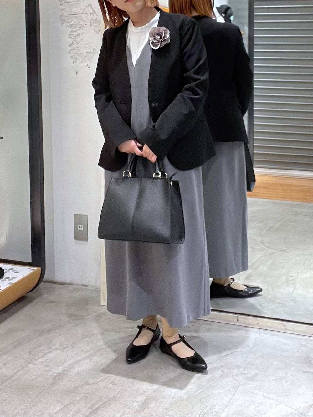 ブラック系のノーカラージャケット、ホワイト系のシャツ/ブラウス、ブラック系のショルダーバッグを着用したレディースの冬コーディネートの4枚目の写真