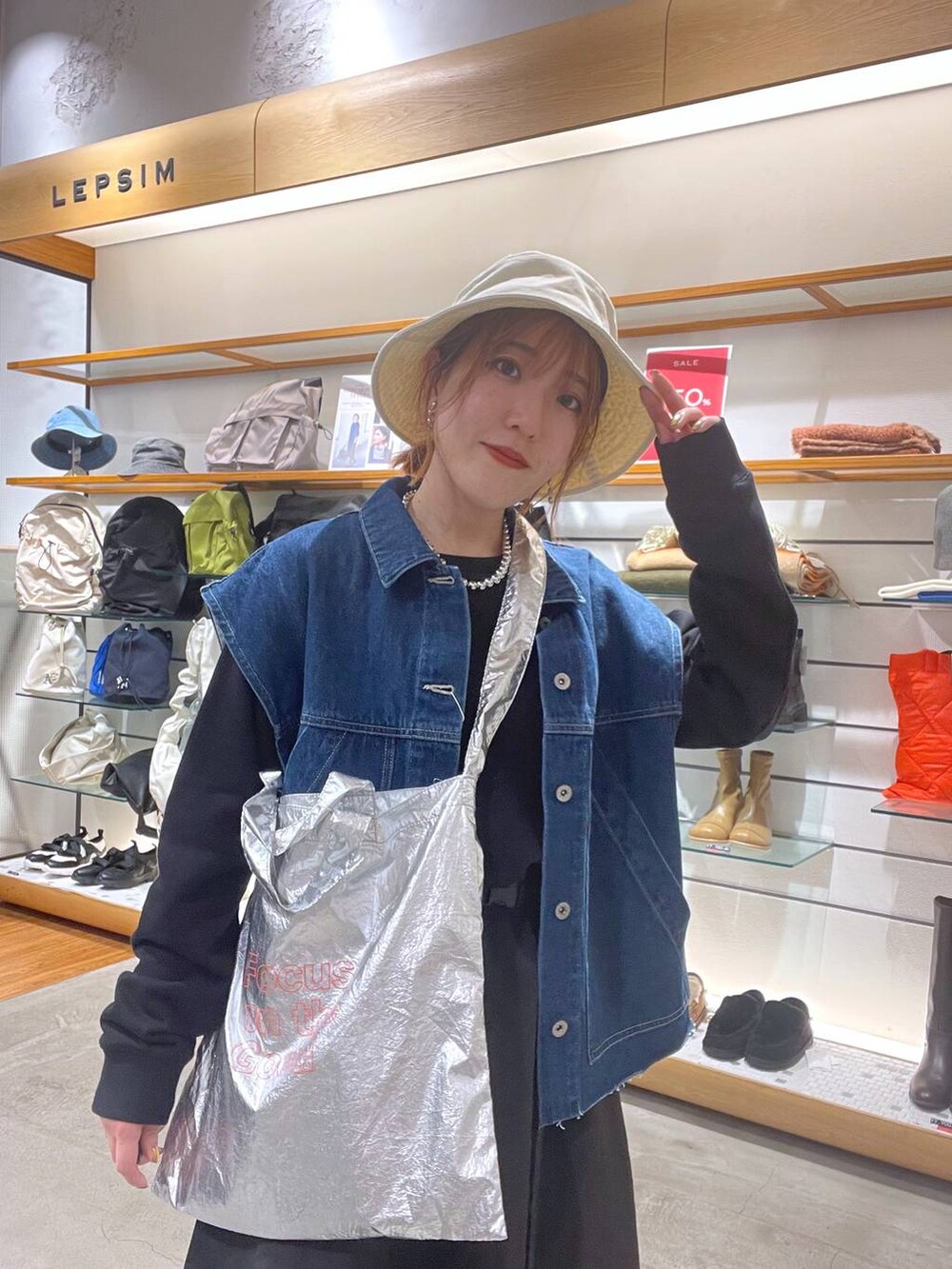 ブラック系のワンピース、シルバー系のトートバッグ、ブルー系のベストを着用したレディースの春コーディネートの4枚目の写真