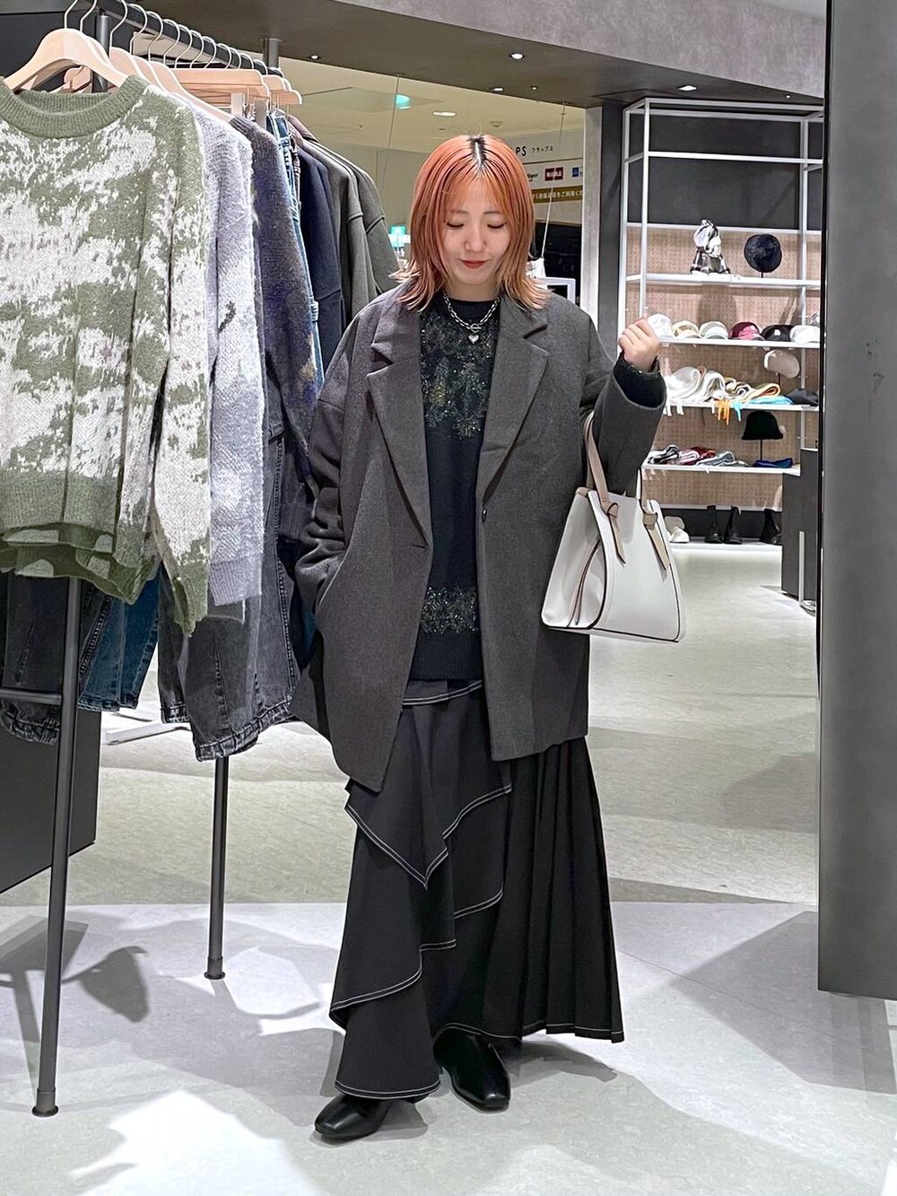 グレー系のテーラードジャケット、ブラック系のブーツ、ブラック系のスカートを着用したレディースの冬コーディネートの2枚目の写真