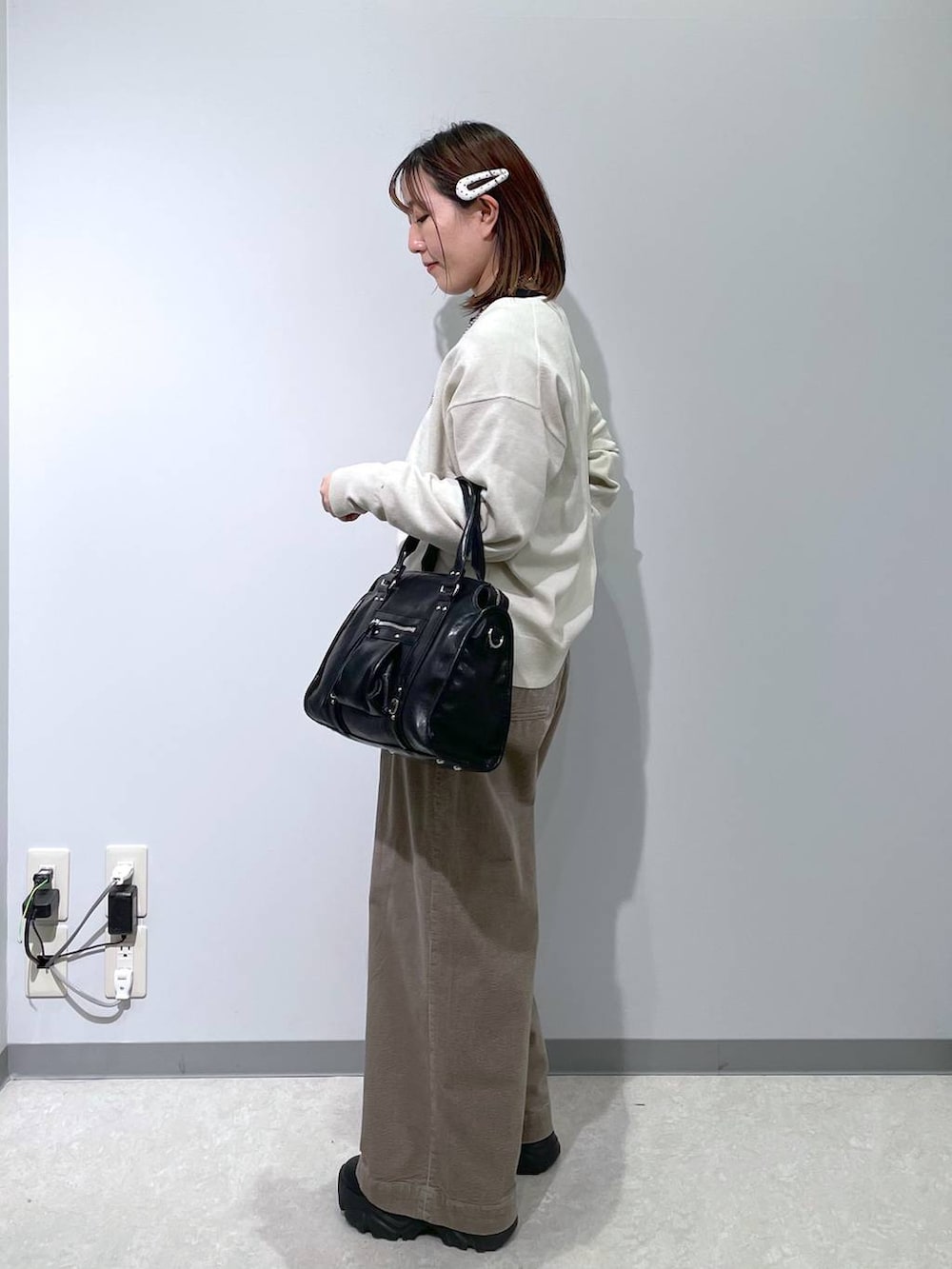 ブラック系のボストンバッグ、ベージュ系のその他パンツ、グレー系のニット/セーターを着用したレディースの冬コーディネートの4枚目の写真