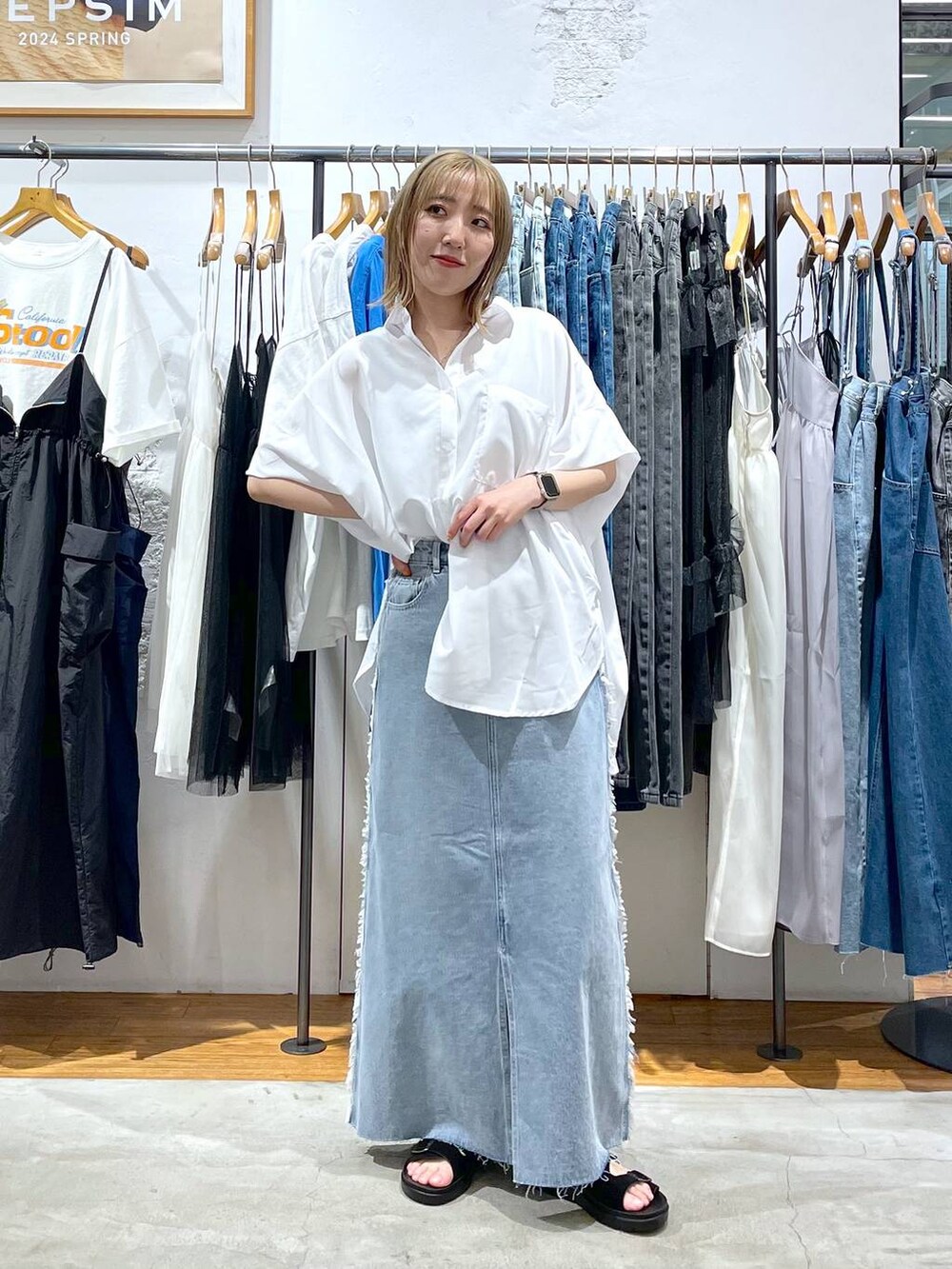ホワイト系のシャツ/ブラウス、ブルー系のデニムスカートを着用したレディースの春コーディネートの2枚目の写真