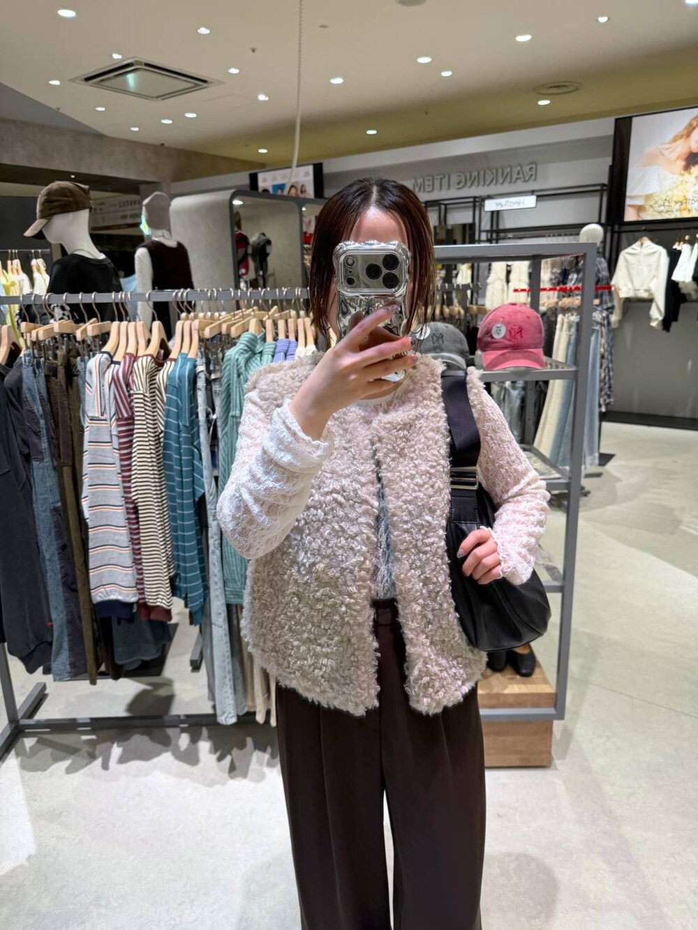ベージュ系のベスト、ブラウン系のスラックス、ホワイト系のTシャツ/カットソーを着用したレディースの秋コーディネートの3枚目の写真