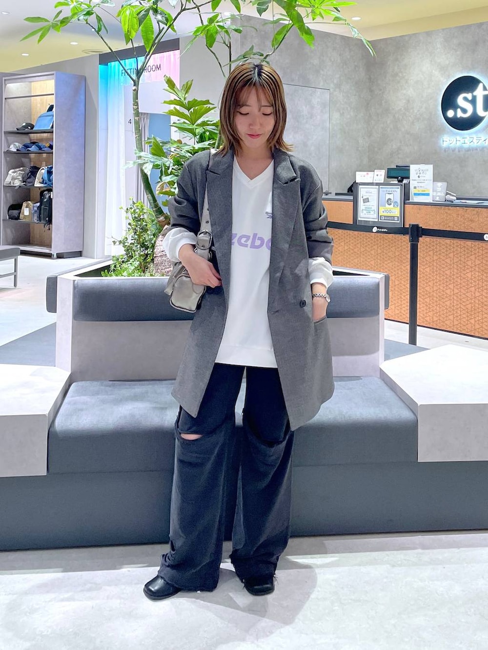 シルバー系のショルダーバッグ、ブラック系のブーツ、ブラック系のスウェットパンツを着用したレディースの秋コーディネートの2枚目の写真