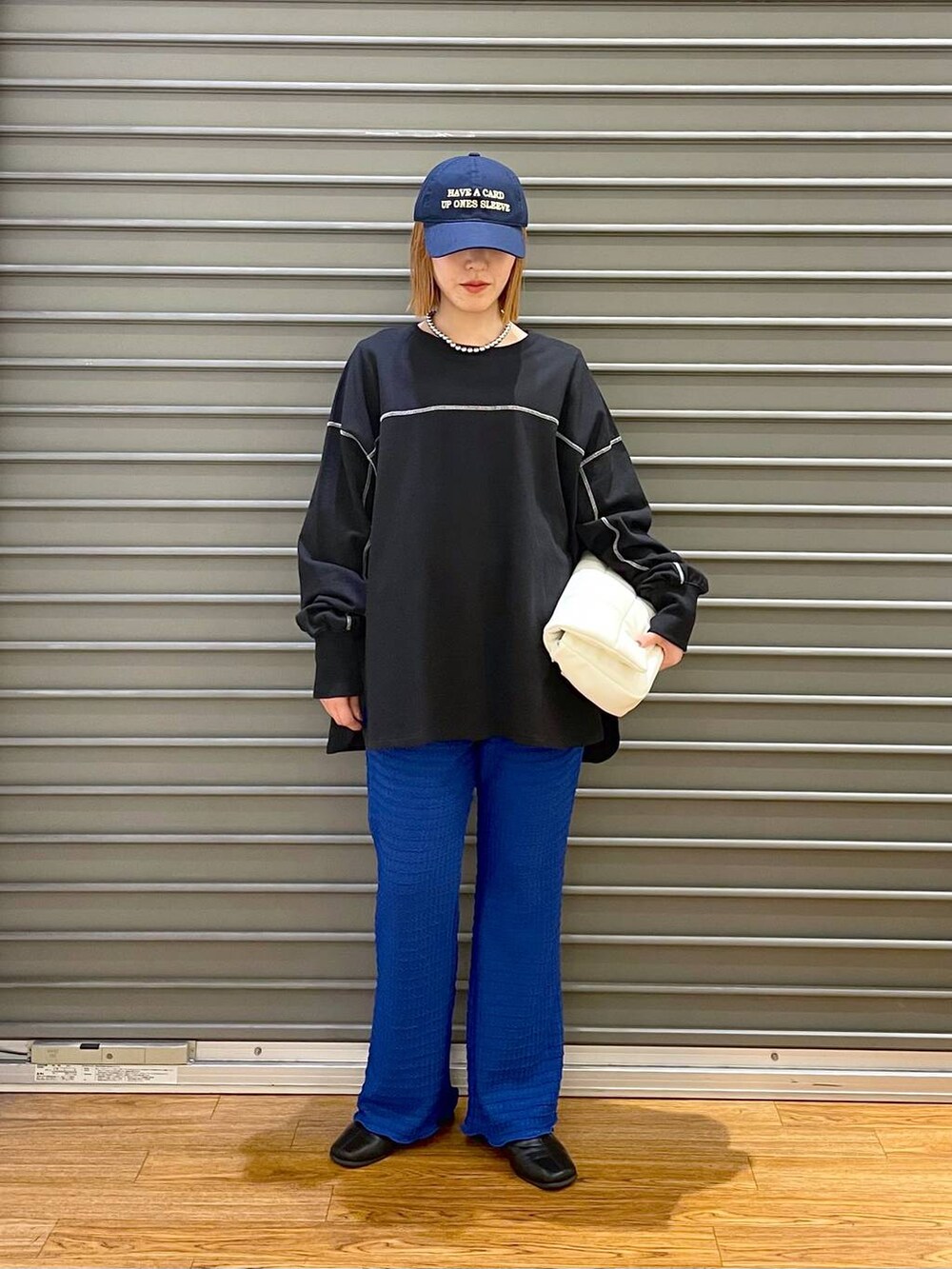 ホワイト系のショルダーバッグ、ブルー系のキャップ、ブラック系のマタニティウェア/グッズを着用したレディースの春コーディネートの3枚目の写真