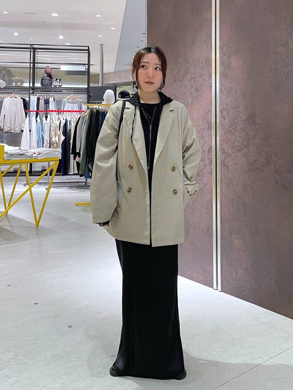 ブラック系のショルダーバッグ、ベージュ系のテーラードジャケット、ブラック系のパーカーを着用したレディースの春コーディネートの3枚目の写真