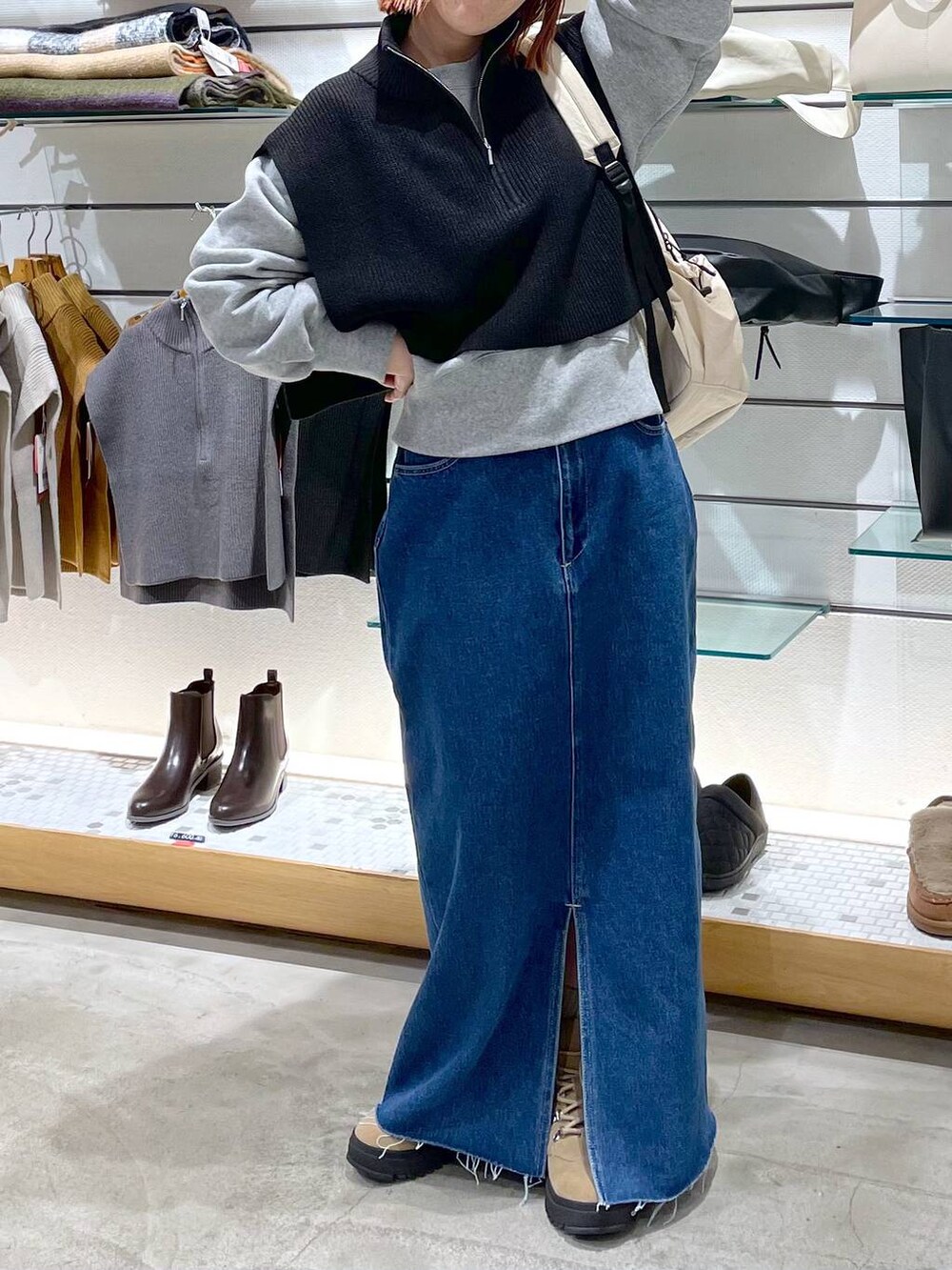 ブラック系のニット/セーター、ベージュ系のブーツ、ホワイト系のバックパック/リュックを着用したレディースの冬コーディネートの6枚目の写真