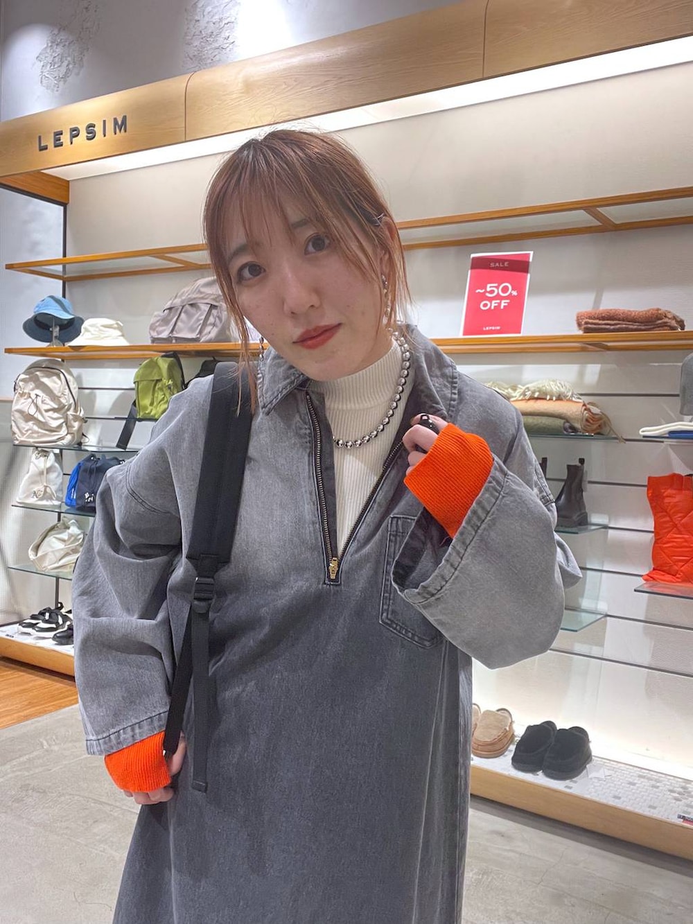 ブラウン系のブーツ、ブラック系のバックパック/リュック、ホワイト系のニット/セーターを着用したレディースの春コーディネートの3枚目の写真