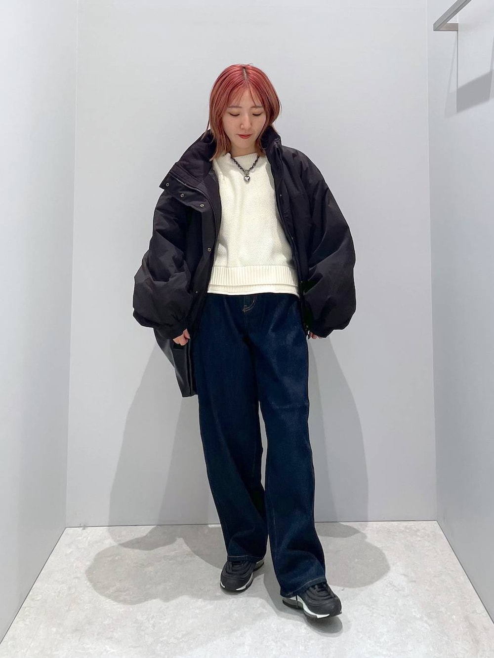 ブラック系のショルダーバッグ、ホワイト系のニット/セーター、ブラック系のその他アウターを着用したレディースの秋コーディネートの3枚目の写真