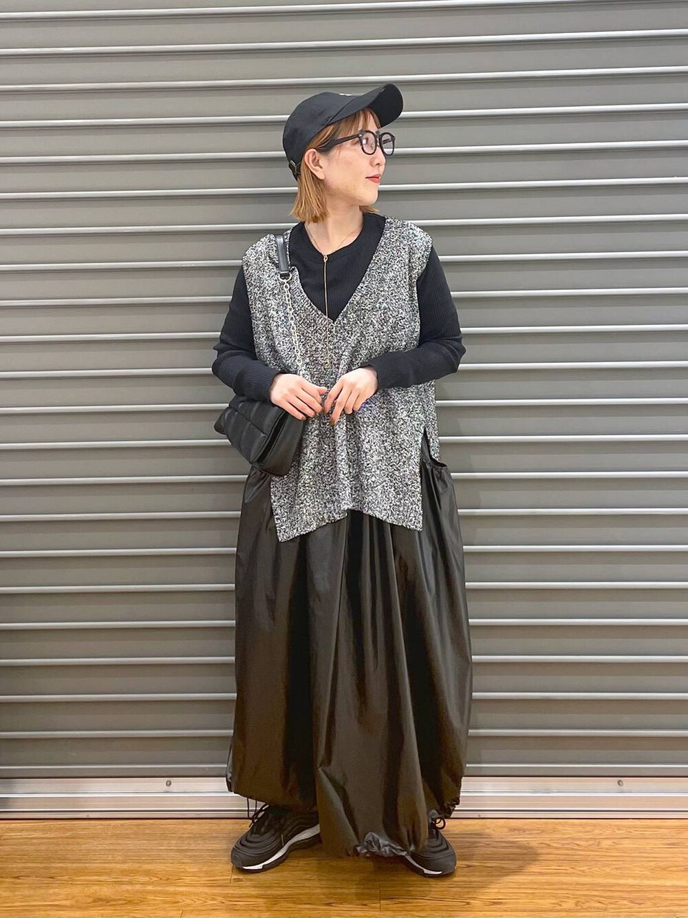 ブラック系のショルダーバッグ、ブラック系のベスト、ブラック系のTシャツ/カットソーを着用したレディースの春コーディネートの2枚目の写真