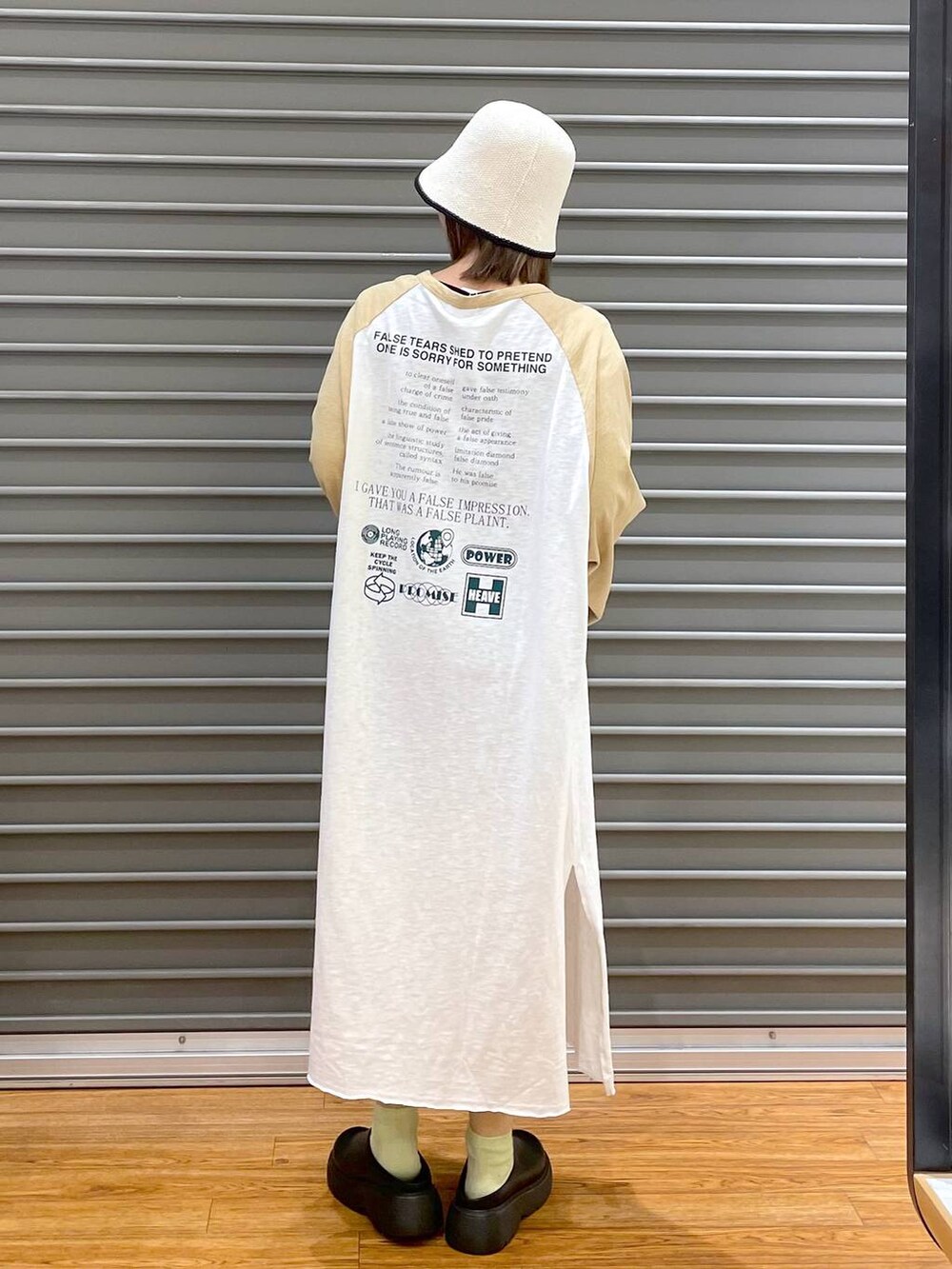 ベージュ系のワンピース、ブラック系のショルダーバッグ、ブルー系のベストを着用したレディースの春コーディネートの4枚目の写真