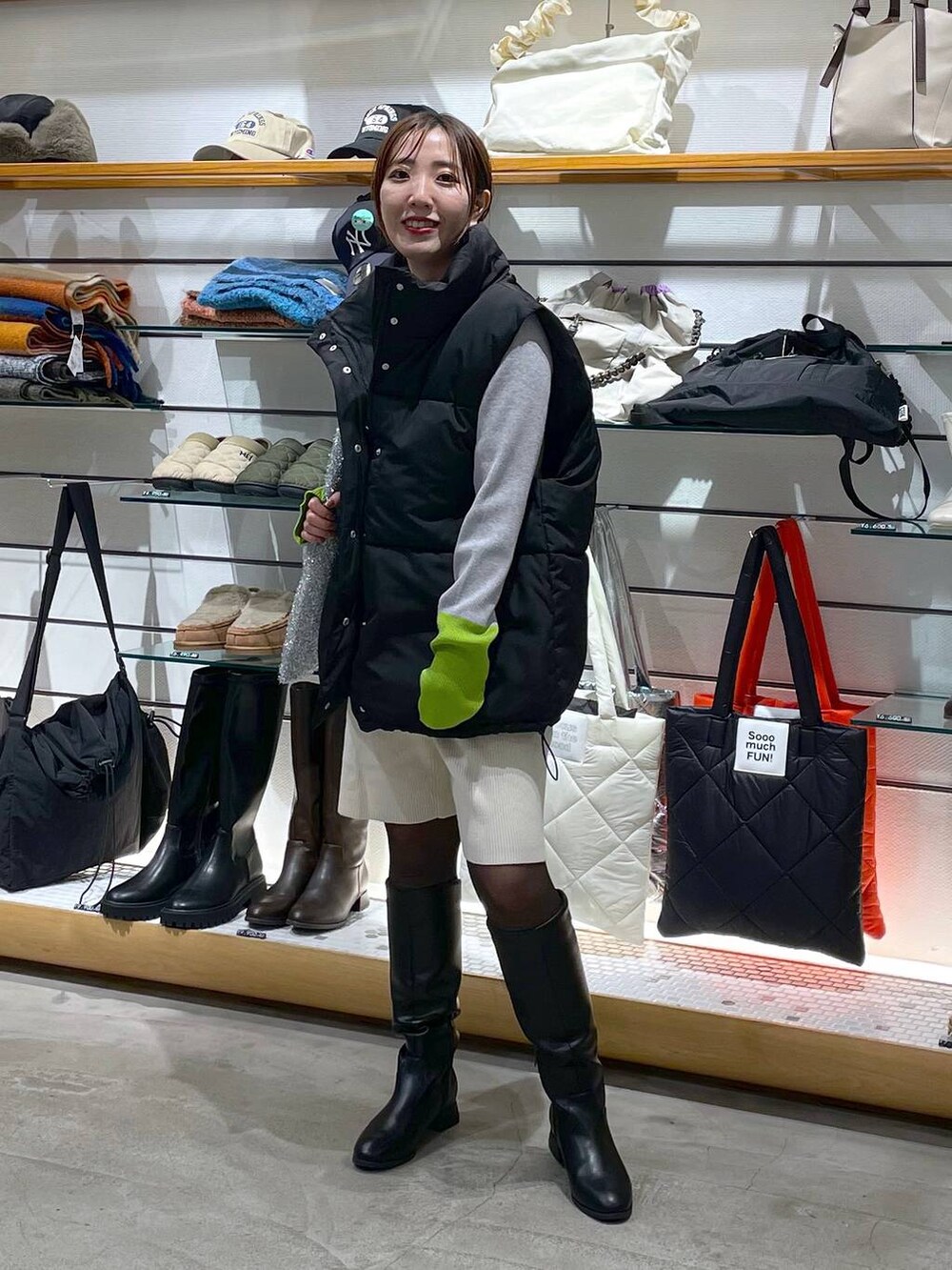 ホワイト系のその他パンツ、シルバー系のショルダーバッグ、ブラック系のダウンベストを着用したレディースの冬コーディネートの2枚目の写真