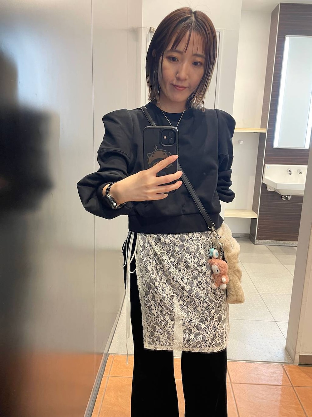 ブラック系のその他パンツ、ブラック系のスウェット、ベージュ系のショルダーバッグを着用したレディースの秋コーディネートの3枚目の写真