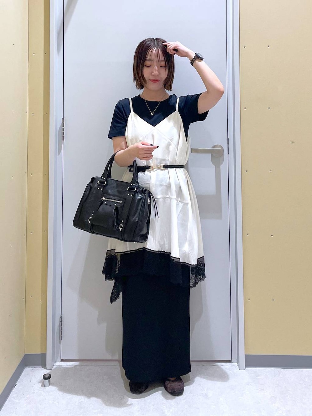 ブラック系のスカート、ブラック系のボストンバッグ、ブラック系のTシャツ/カットソーを着用したレディースの夏コーディネートの5枚目の写真