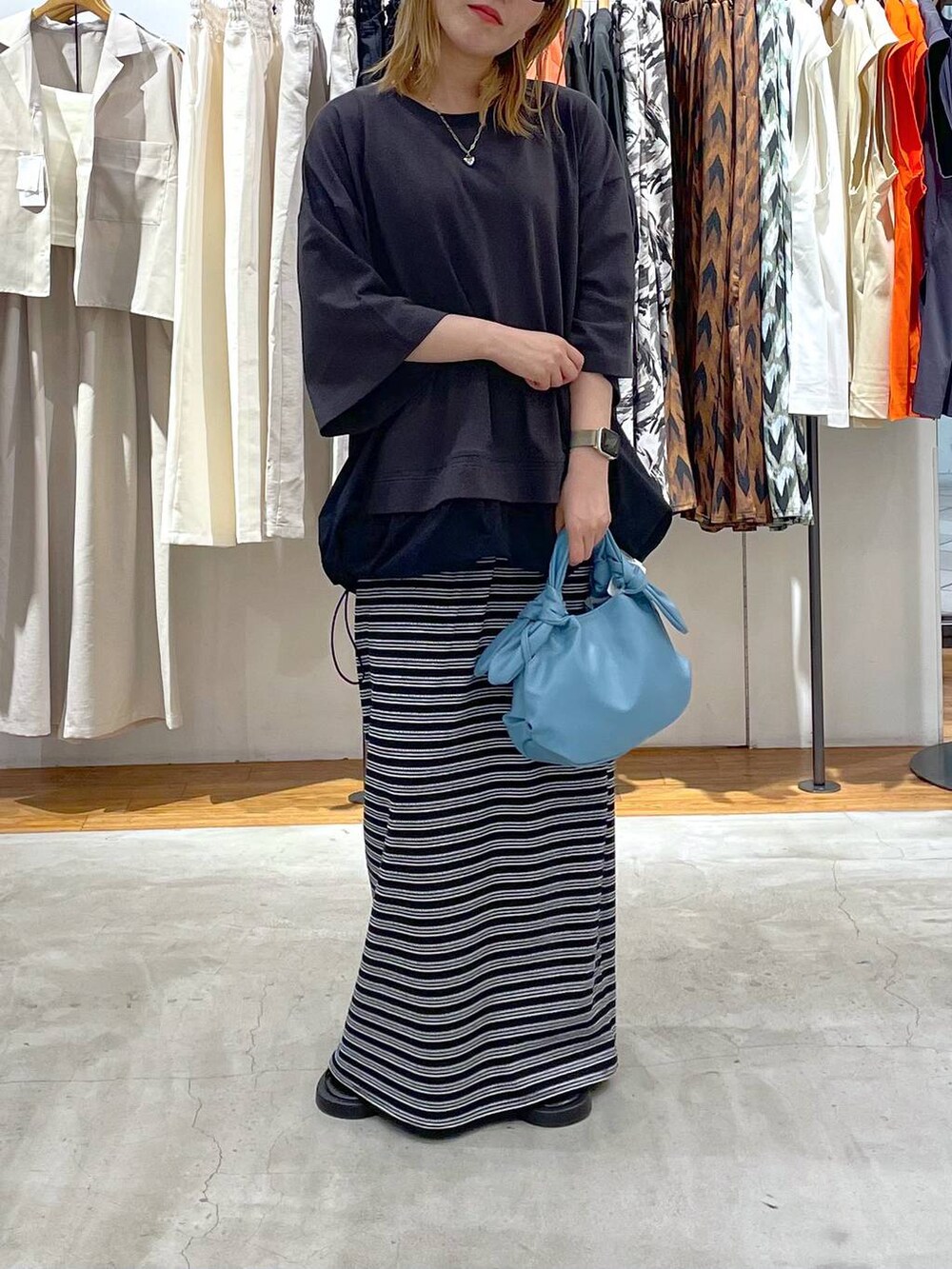 ブラック系のサンダル、ブルー系のショルダーバッグ、グレー系のTシャツ/カットソーを着用したレディースの夏コーディネートの2枚目の写真