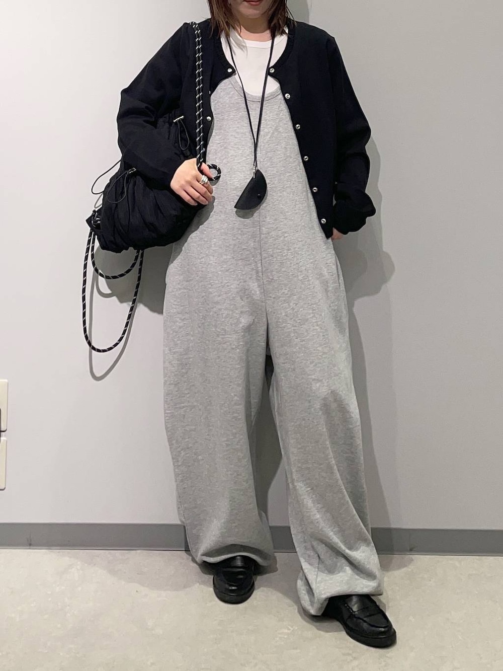 グレー系のつなぎ/オールインワン、ブラック系のバックパック/リュック、ブラック系のカーディガン/ボレロを着用したレディースの春コーディネートの2枚目の写真