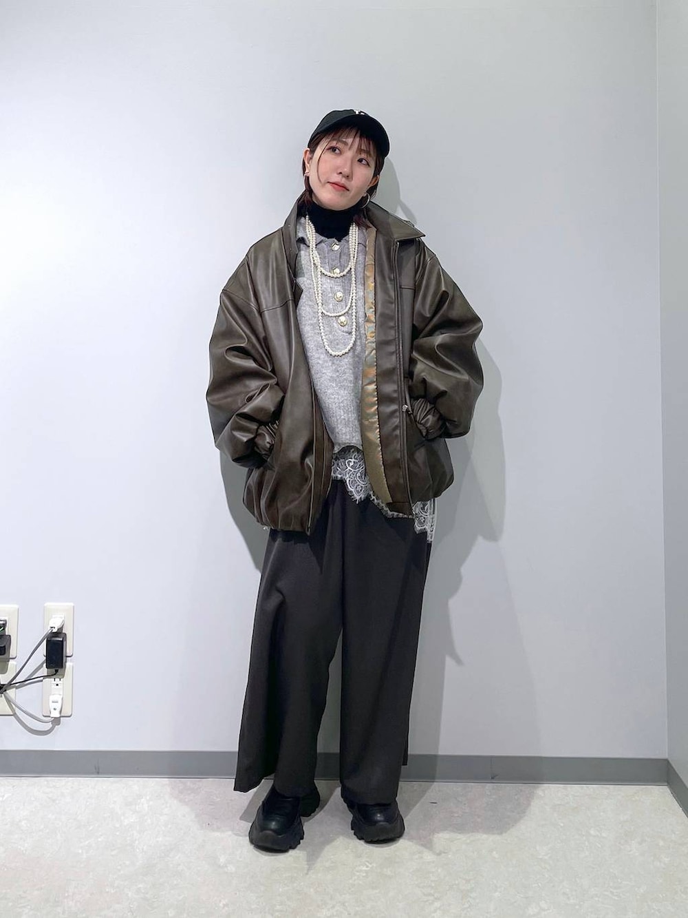 ブラウン系のブルゾン、ブラック系のニット/セーター、グレー系のその他パンツを着用したレディースの冬コーディネートの3枚目の写真