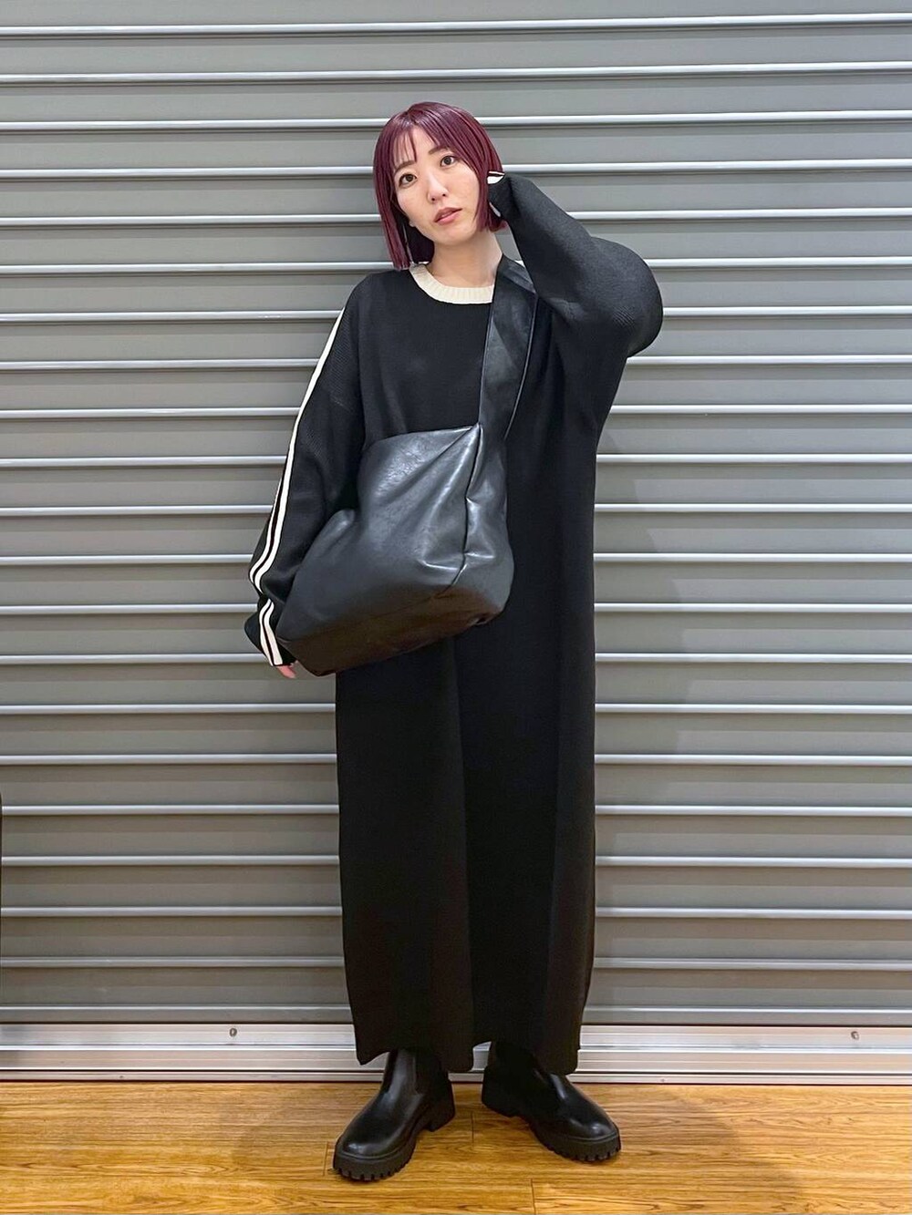 ブラック系のショルダーバッグ、ブラック系のブーツ、ブラック系のワンピースを着用したレディースの冬コーディネートの2枚目の写真